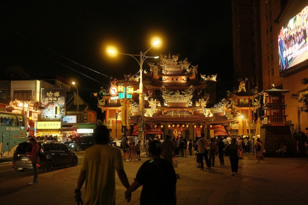 couple walking towards the Songshan Ciyou Temple at night