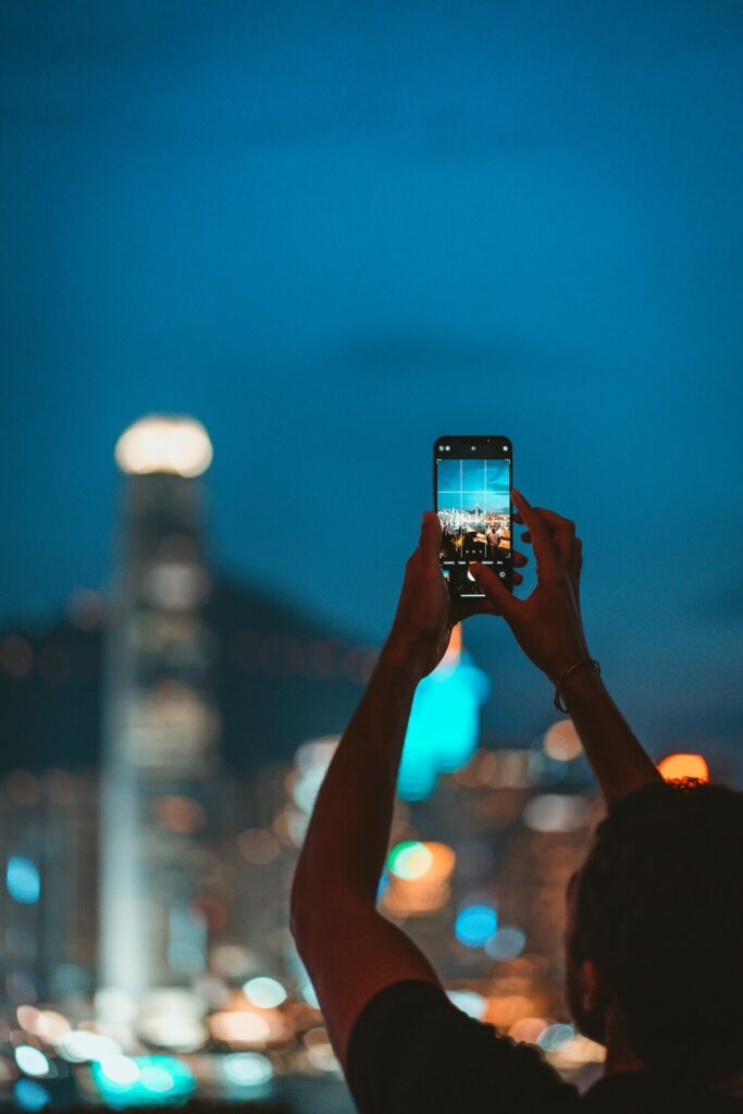 woman taking photo of harbor view from Aqua Restaurant in Tsim Sha Tsui