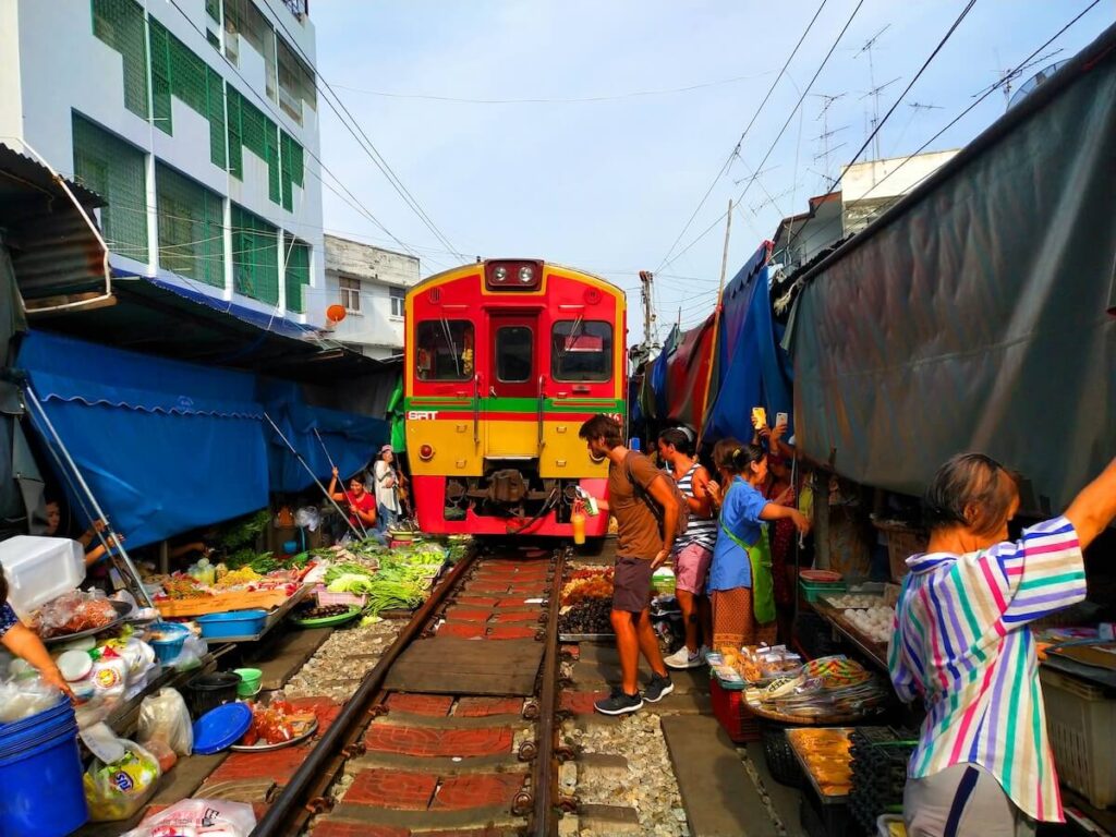 vendors and tourists at the Maeklong Railway Market