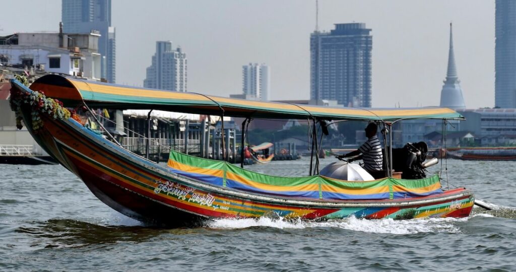 traditional Thai longtail boat cruising through the Chao Phraya River