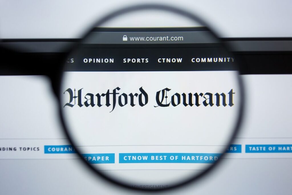 magnifying glass over Hartford Courant newspaper