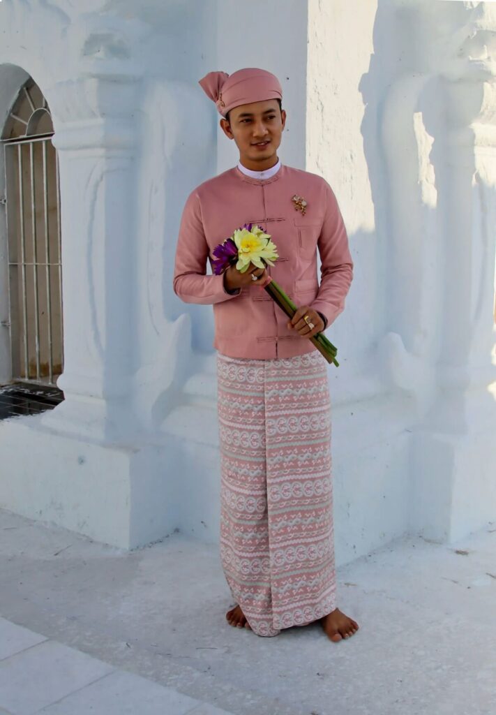 man wearing pink longyi