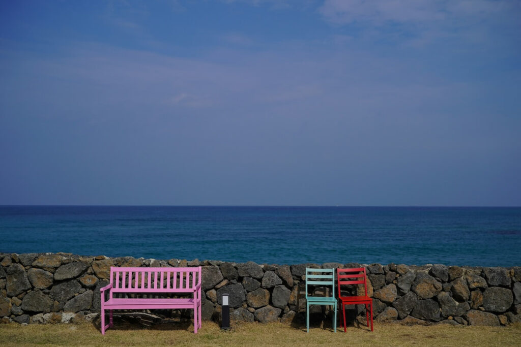 colorful chairs by rock fence in Jeju