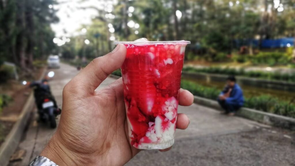 hand holding a cup of strawberry taho