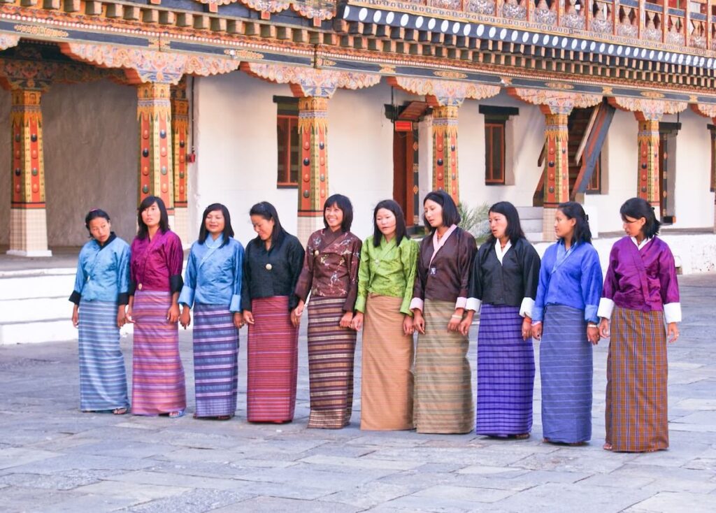 Bhutanese women wearing kira and preparing to rehearse a performance