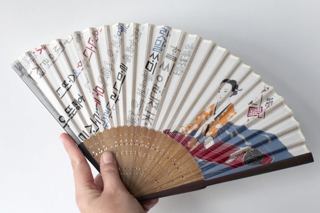 hand holding a Korean paper fan