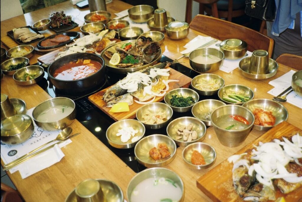 table full of Korean food and bronzeware