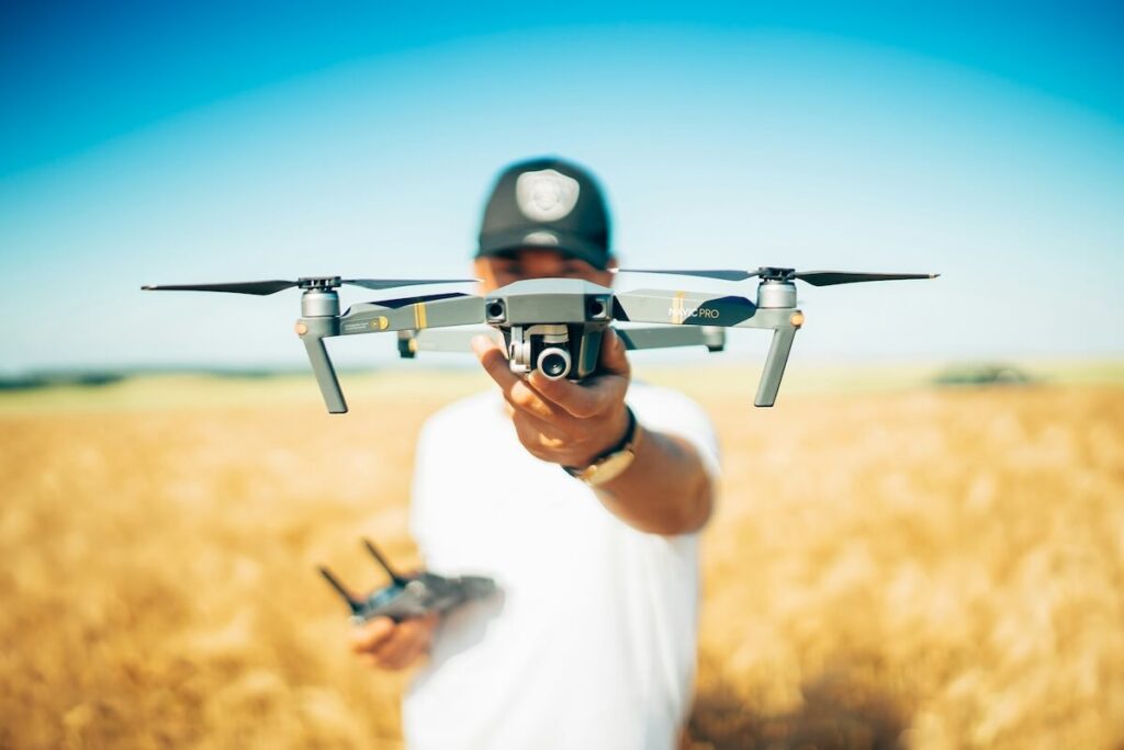 man flying drone in a field