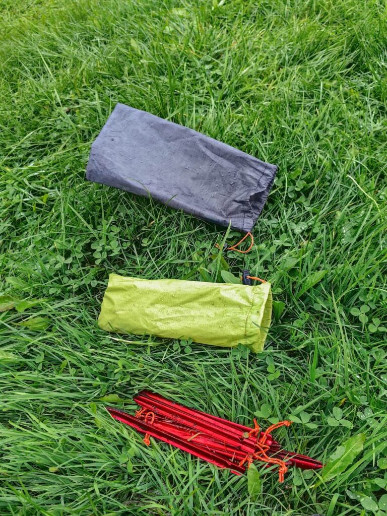 tent stakes and canvas packs on grass