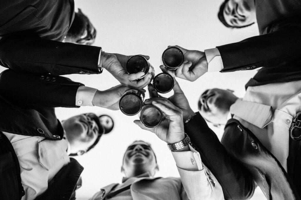 men wearing suits clinking glasses
