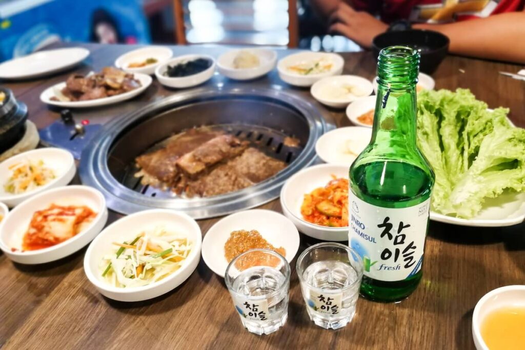 assorted foods, barbecue, and soju in Korean restaurant
